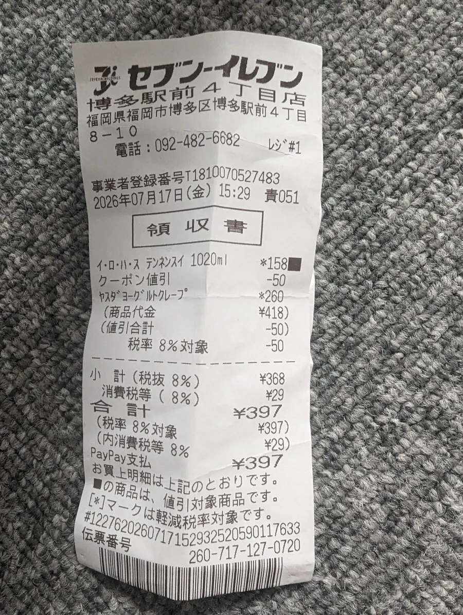 A Japanese convenience store receipt photographed on gray carpet
